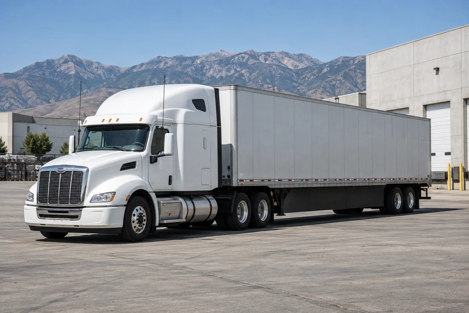 White tractor and gray dry van parked in a Utah industrial yard